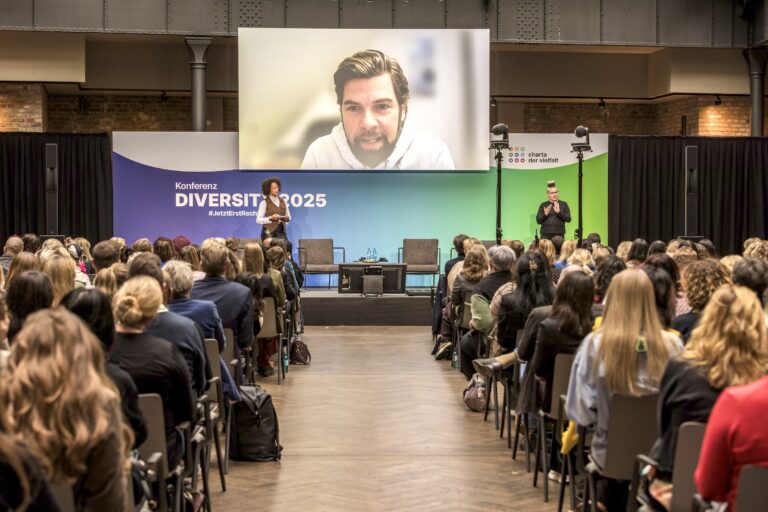 Oliver Bartelt (DMK) berichtete auf der Konferenz DIVERSITY 2025 per Liveschalte wie eine divers-gestaltete Käseverpackung und ein orchestrierter Shitstorm für mehr Bewerber:innen sorgten.