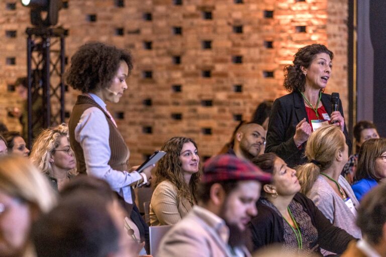 Moderatorin Paula Essam gibt einer Teilnehmenden Person das Wort auf der Konferenz DIVERSITY 2025